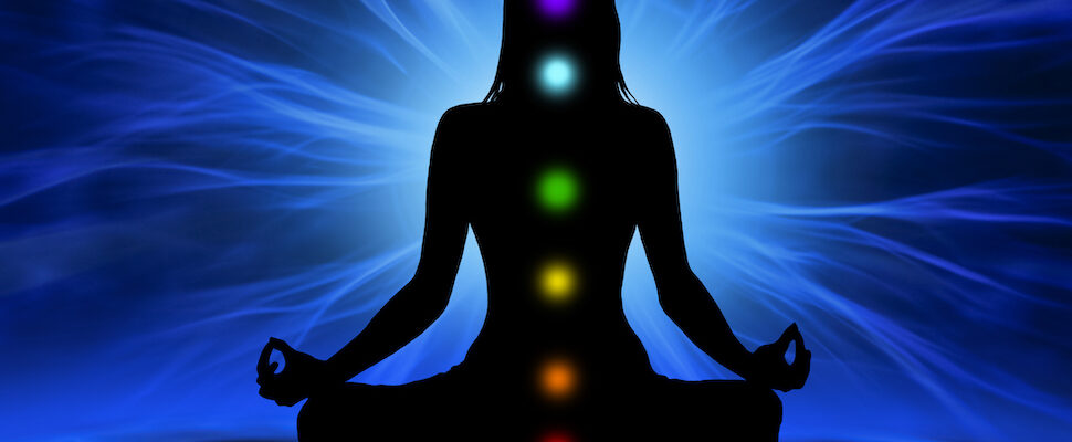 Woman with glowing chakras for what happens when you balance your chakras