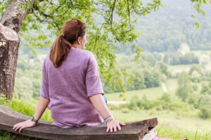 Woman gazing out on nature for holistic healing | blending energy work with coaching